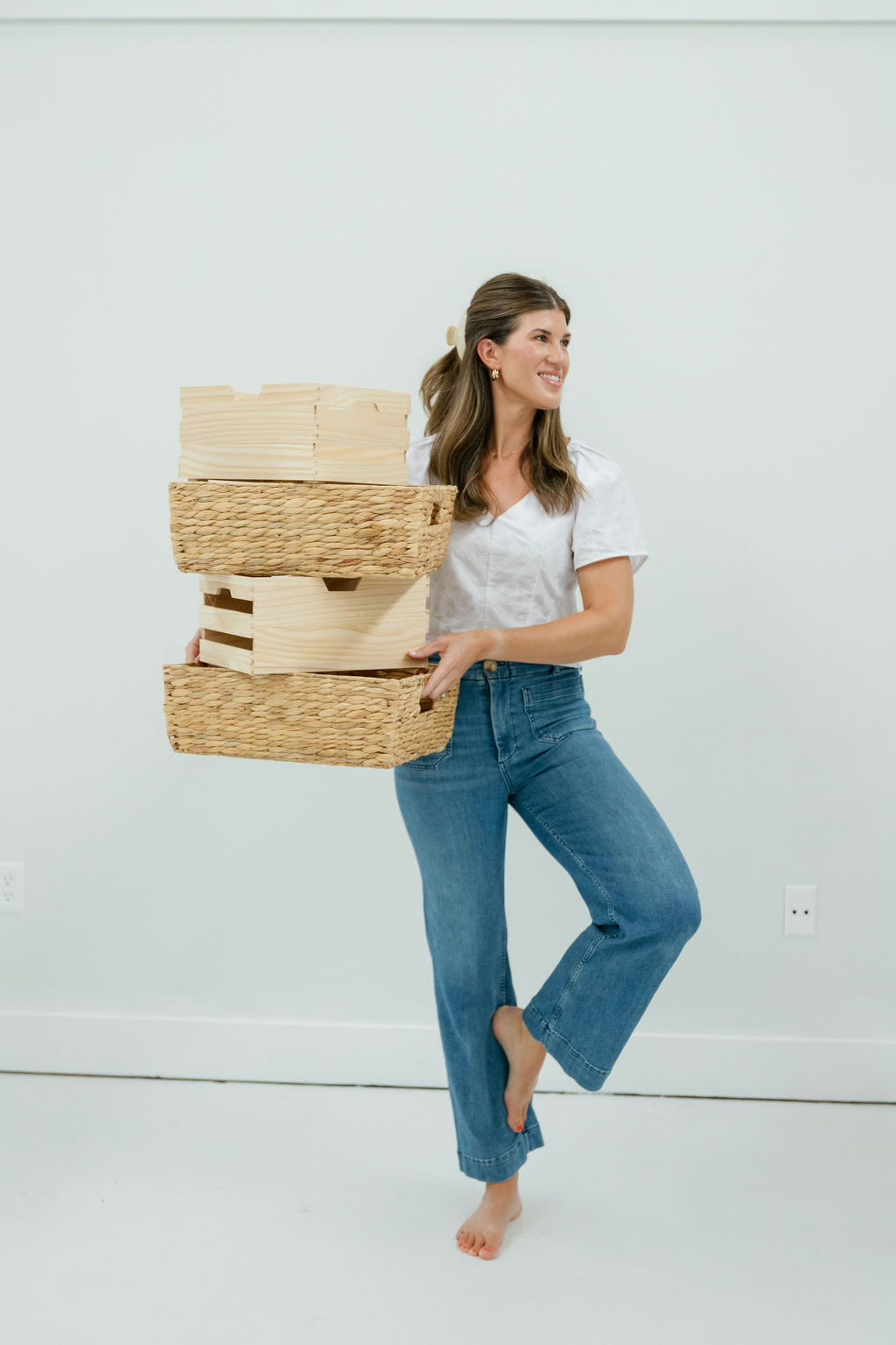 Kristen carrying a stack of storage baskets